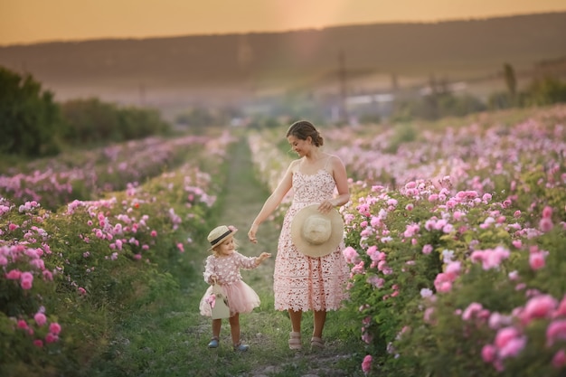 Madre con bambino in un campo naturale con rose selvatiche
