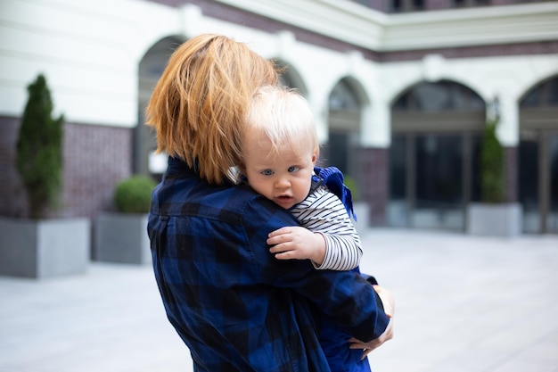 Madre con bambino neonato in abiti eleganti all'aperto su sfondo urbano