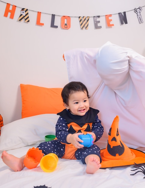 Madre con figlia in costume per festeggiare Halloween a casa. Bambino con la mamma alla decorazione della camera da letto nella stagione autunnale.