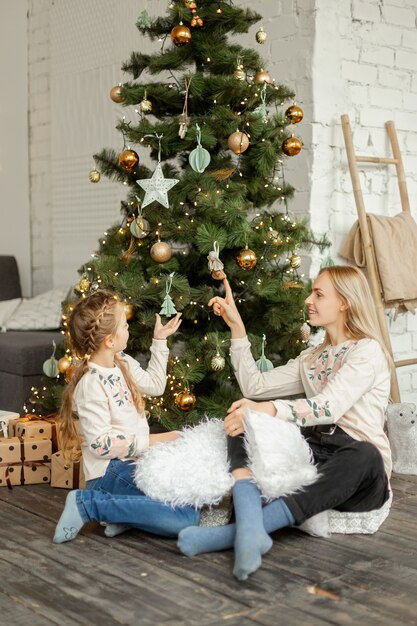 Madre con figlia vicino all'albero di Natale