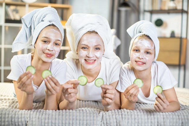 Madre con figlie che fanno maschera vitaminica per la pelle del viso