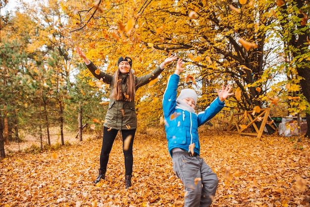 Madre con figlio che gioca all'aperto al parco cittadino d'autunno