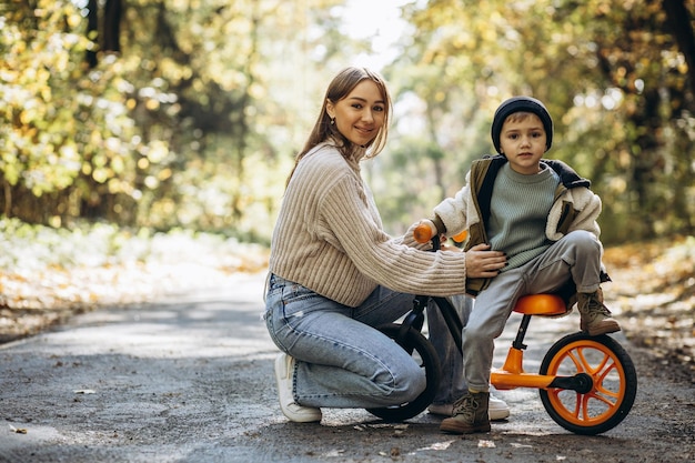 Madre con figlio piccolo che insegna ad andare in bicicletta nel parco