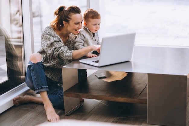 Madre con figlio piccolo che lavora sul computer a casa