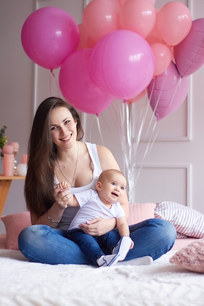 Madre con il suo bambino piccolo nella camera da letto interna chiara