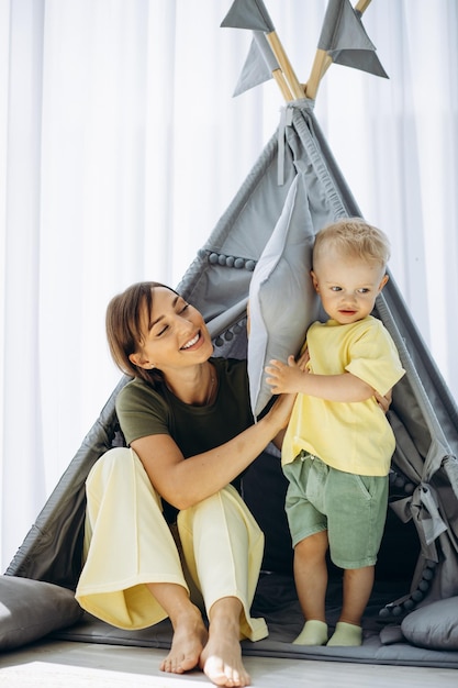 Madre con il suo piccolo figlio che gioca nella tenda di Wigwam