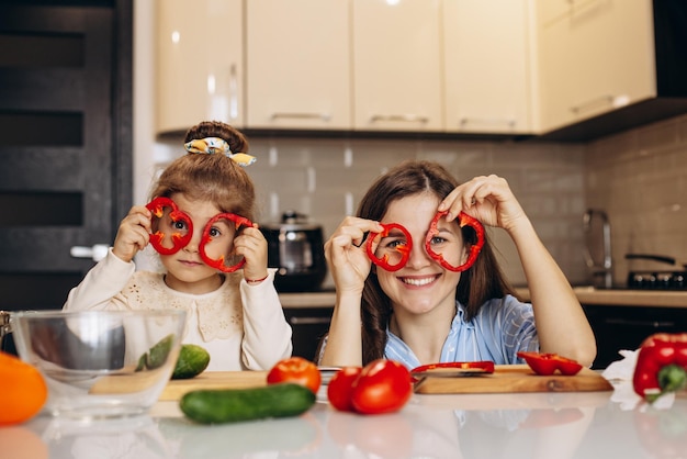 Madre con la figlia che prepara l'insalata alla cucina