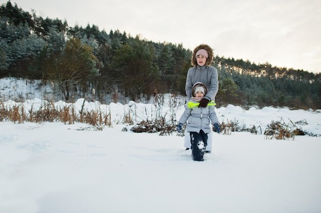 Madre con la figlia della neonata nella natura di inverno. All'aperto nella neve.