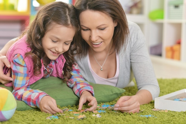 Madre con la piccola figlia che raccoglie puzzle