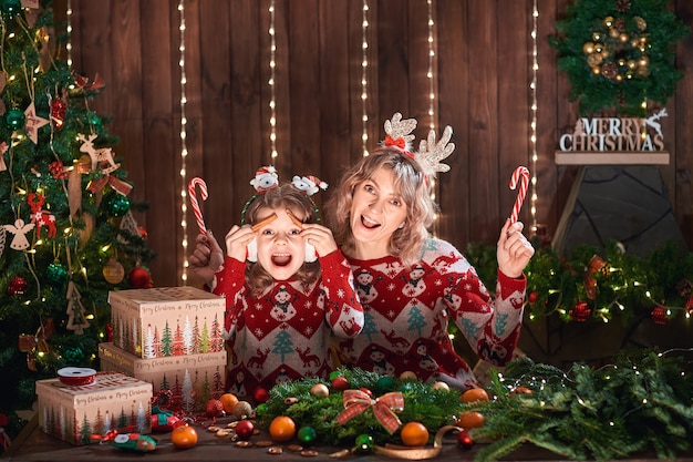 Madre con la ragazza del bambino vicino all'albero di Natale.