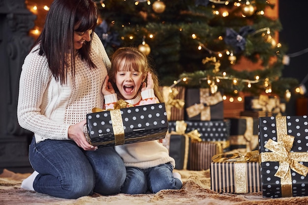 Madre con la sua piccola figlia che celebra il natale con i regali.