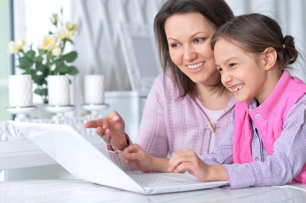 Madre con la sua piccola figlia che usa il computer portatile