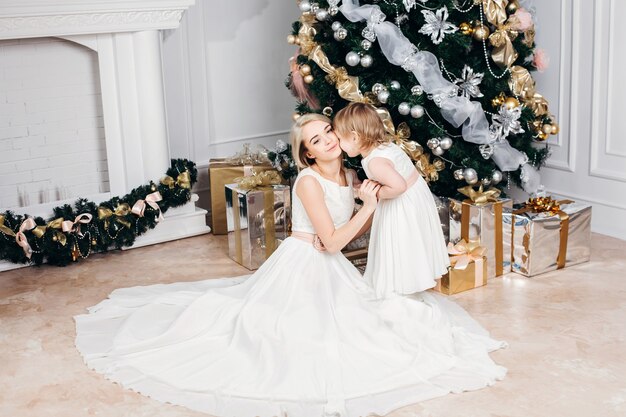 Madre con la sua piccola figlia vicino all'albero di Natale a casa