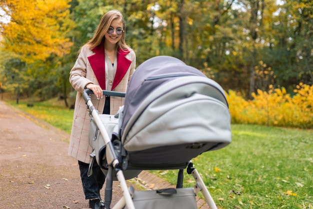 Madre con passeggino passeggiate nella sosta di autunno