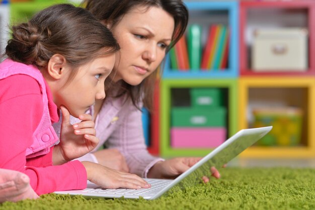 Madre con sua figlia che gode di un computer portatile