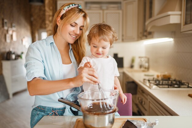 Madre con sua figlia che mescola cioccolato fuso