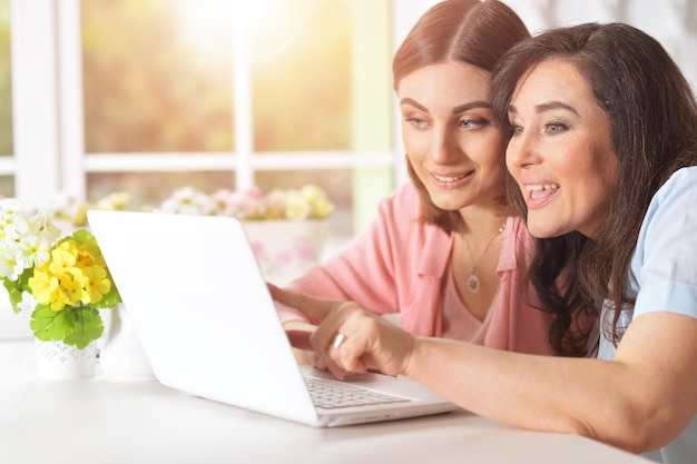 Madre con sua figlia con un laptop al tavolo