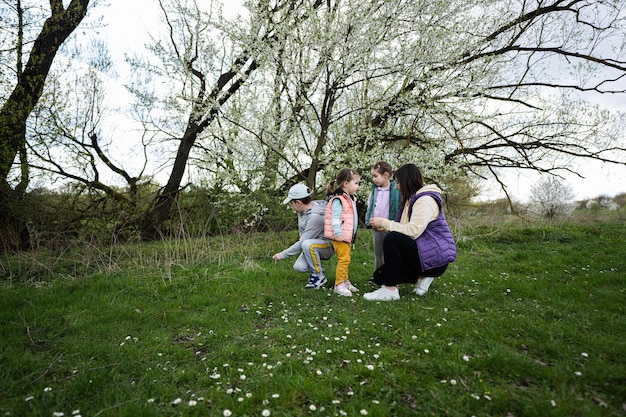 Madre con tre bambini nel prato primaverile