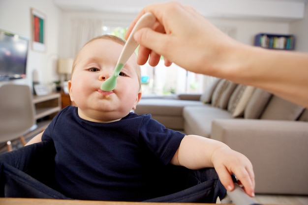 Madre dando cibo al bambino a casa