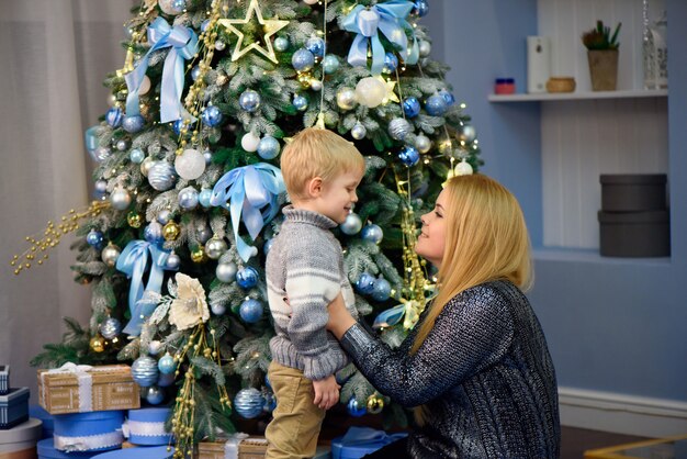 Madre di famiglia felice e figlio piccolo bambino che giocano a casa in vacanza di Natale. Vacanze di Capodanno