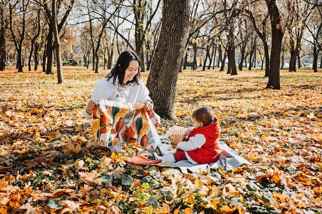 Madre di famiglia felice e piccola figlia del bambino che si divertono insieme nel picnic autunnale