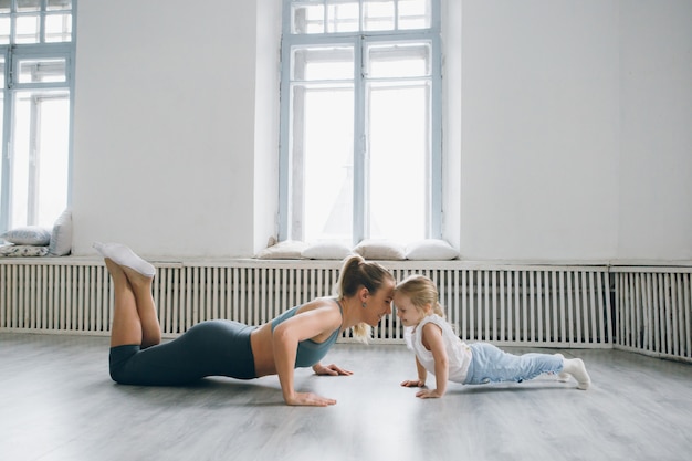 Madre e bambina fanno esercizi insieme in palestra