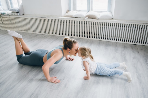 Madre e bambina fanno esercizi insieme in palestra