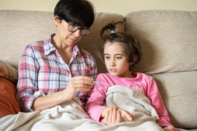 Madre e bambina sedute sul divano