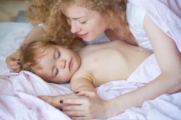 Madre e bambino che dormono nel letto Sonno tranquillo Infanzia prima di coricarsi e concetto di famiglia closeup ritratto interno