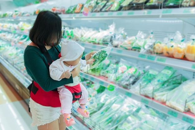 Madre e bambino che fanno la spesa al supermercatoLa donna tailandese ha una figlia