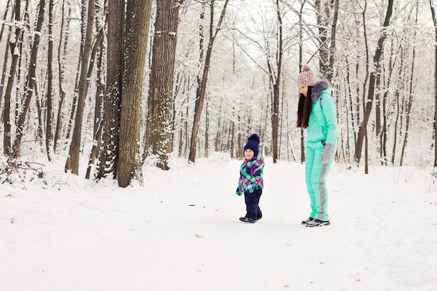 Madre e bambino che giocano con la neve all'aperto.