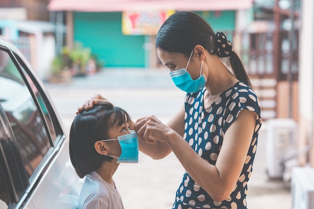 Madre e bambino che indossano una maschera per proteggere il virus corona