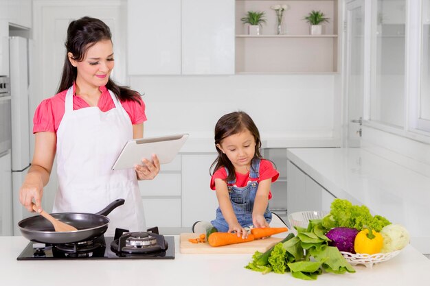 Madre e bambino con il tablet in cucina