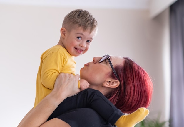 Madre e bambino con sindrome di Down che esplorano la creatività con blocchi giocattolo che si godono un'attività rilassante