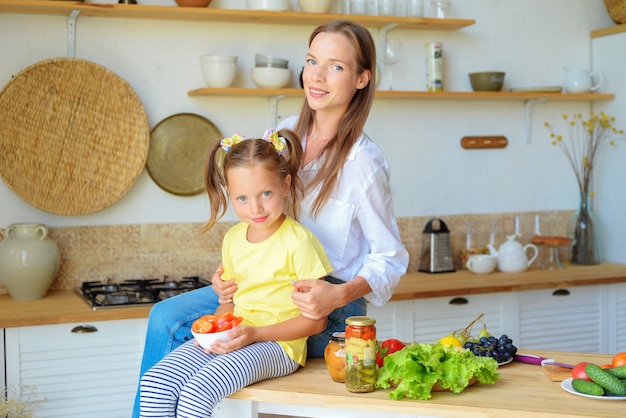 Madre e bambino cucinano cibo sano insieme in cucina e si divertono