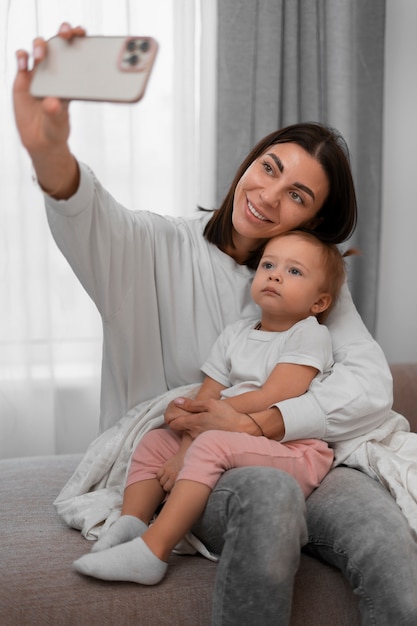 Madre e bambino del colpo medio che prendono selfie