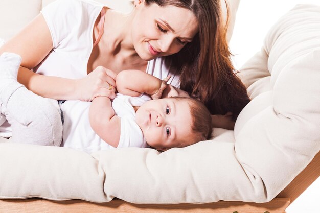 Madre e bambino divertente comunicano sul letto