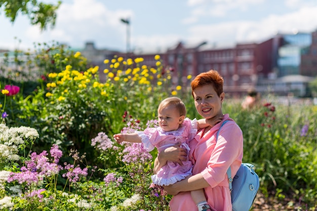 Madre e bambino in posa vicino ai fiori