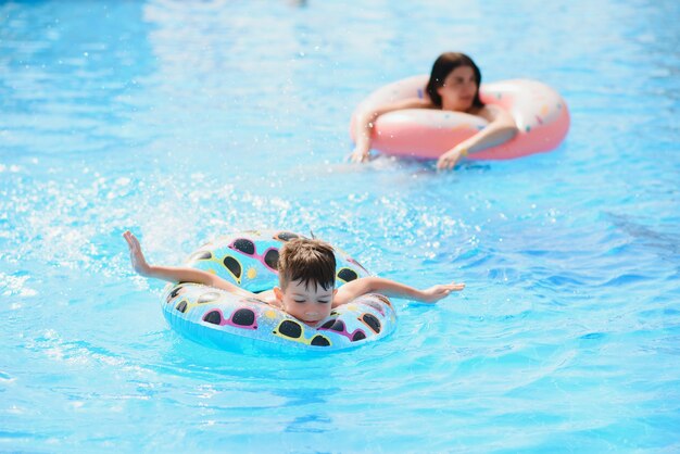 madre e bambino nella piscina all'aperto del resort tropicale. mamma e bambino che giocano in acqua.