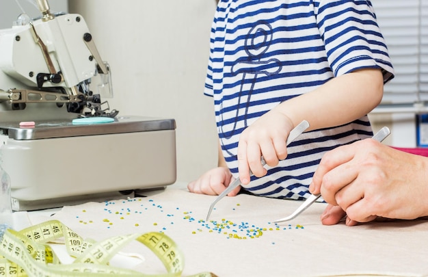 Madre e bambino realizzano un motivo di perline sul tessuto Workplace per la creatività artigianale