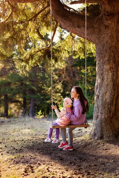 Madre e bambino su un'altalena nel parco