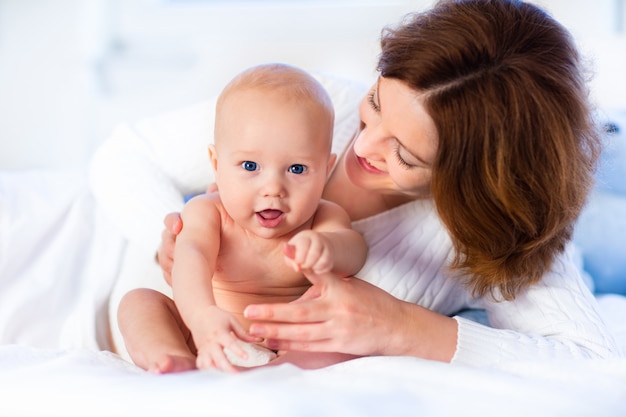 Madre e bambino su un letto bianco