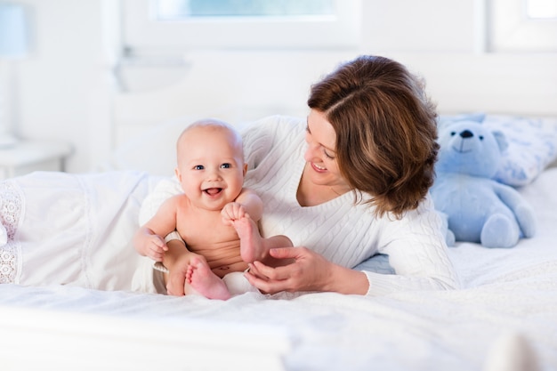 Madre e bambino su un letto bianco