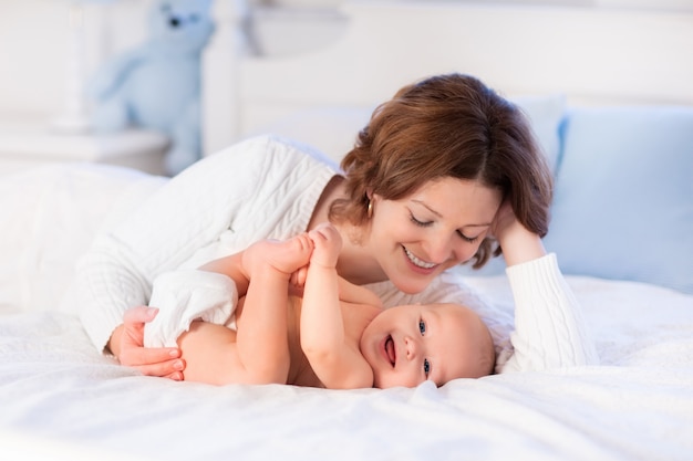 Madre e bambino su un letto bianco