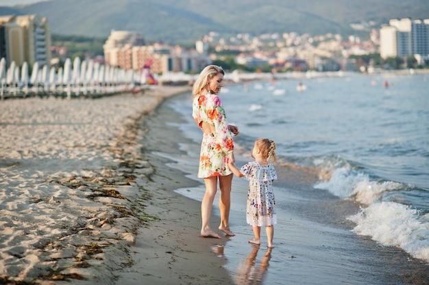 Madre e bella figlia divertendosi sulla spiaggia Ritratto di donna felice con una bambina carina in vacanza