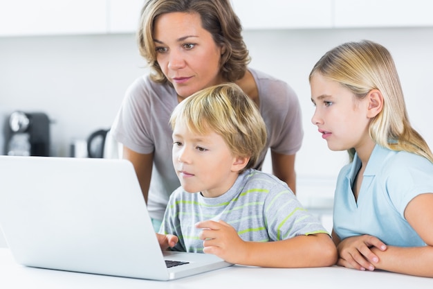 Madre e figli che utilizzano computer portatile