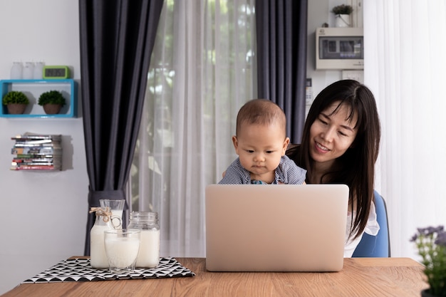 madre e figli che utilizzano laptop a casa.