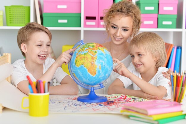 Madre e figli guardando il globo