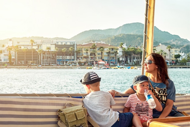 Madre e figli si rilassano in barca a vela in mare lungo la costa di Marmaris contro le montagne