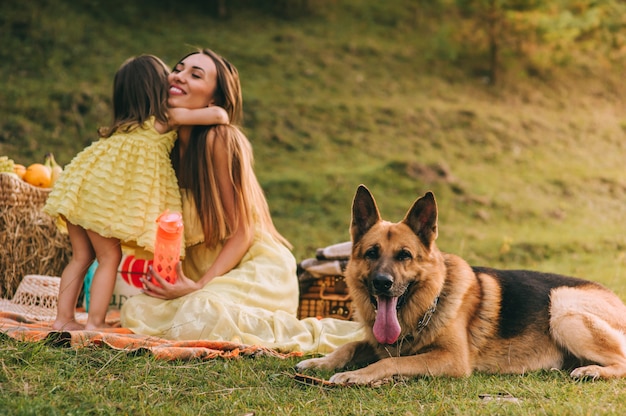 madre e figlia a un picnic con un cane